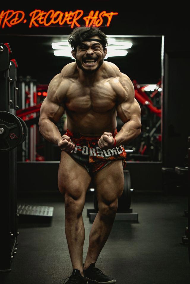 Coach displaying her muscular physique, showcasing her strength and fitness level.